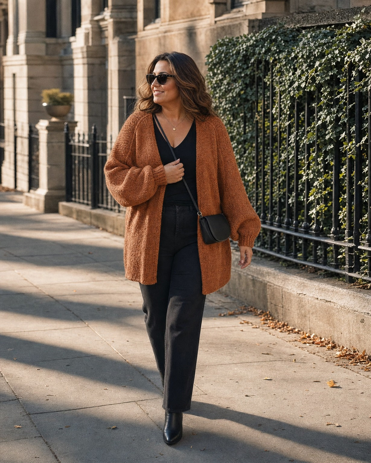 Curvy woman wearing the rust cardigan in size XL on a city sidewalk